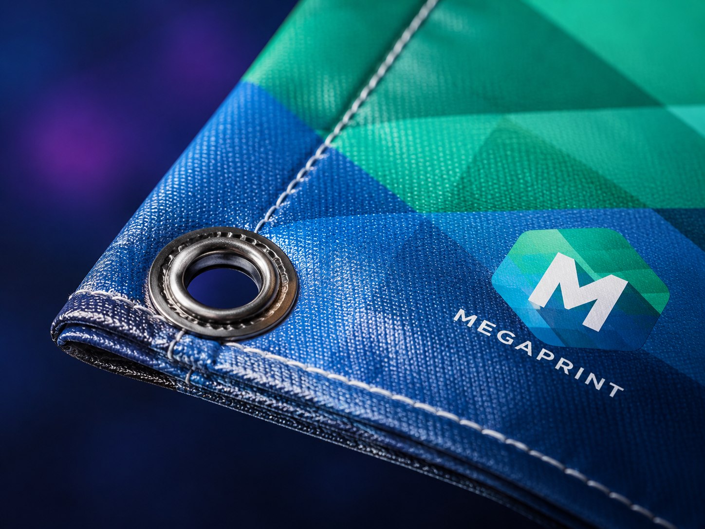 Close-up of vinyl banner material showing hemmed edge and grommet detail with Megaprint logo