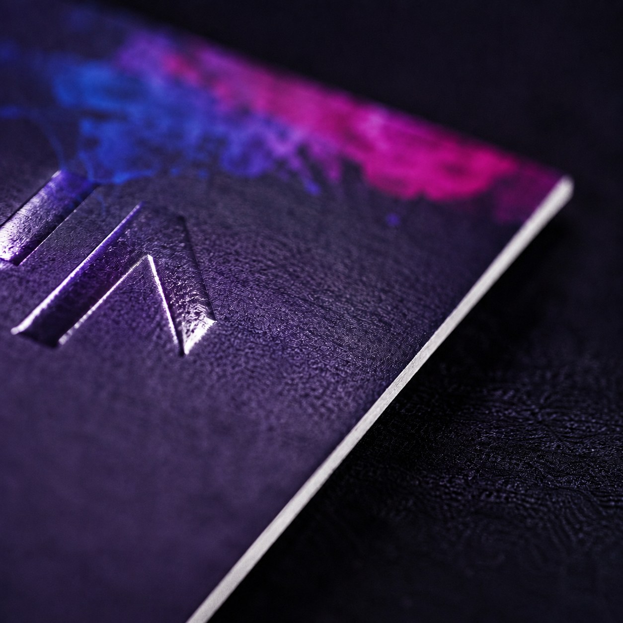 Macro close-up of premium cardstock texture and embossed finish on a Megaprint business card